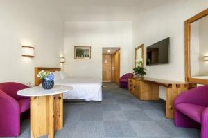 伊斯塔潘德拉萨尔兰乔圣迭戈格兰Spa度假酒店的酒店客房,配有一张床和两张紫色椅子