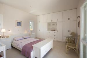 索瓦拉Villa Waterfront的白色卧室配有床和桌子