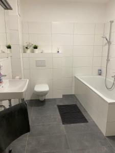 EbenthalWunderschöne, neue Wohnung mit großer Terrasse的带浴缸、卫生间和盥洗盆的浴室