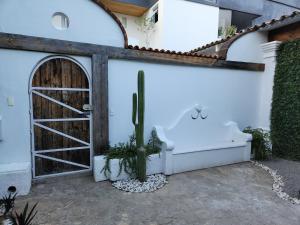 瓦哈卡市Hermosa Hacienda Las Heliconias的白色的建筑,有门和仙人掌