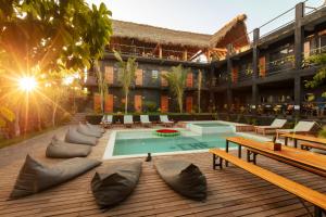 埃斯孔迪多港Che Puerto Escondido Hostel & Bar Adults Only的一个带游泳池和长椅的度假胜地和一座建筑