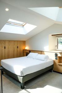 Banca国际之家埃勒奎纳酒店的卧室配有一张白色大床和天窗