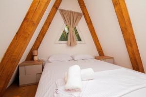 采蒂涅Vukova dolina的卧室配有白色的床和2条毛巾