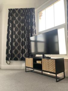布里斯托Stylish 91sqm Victoria 2 bedroom Apartment的客厅配有平面电视和窗户。