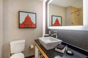 麦迪逊Cambria Hotel Madison East的一间带卫生间、水槽和镜子的浴室