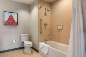 麦迪逊Cambria Hotel Madison East的浴室配有卫生间、浴缸和水槽。