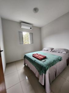 多拉杜斯DOURADOS GUEST FLAT PEDRA BONITA的一间卧室配有一张带绿毯的床