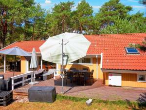维斯特索马肯Holiday home Nexø X的一个带桌子和白色遮阳伞的庭院