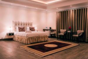 巴哈瓦尔布尔Falettis Grand Bahawalpur的卧室配有一张床和一张桌子及椅子