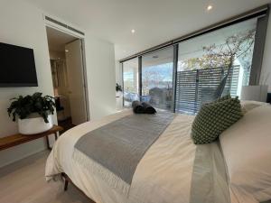 金斯顿Lakeview Luxe - EV charger, Pool, Gym, Location +的一间卧室设有一张大床和大窗户