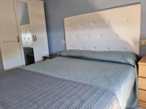 VilladesusoAlojamiento Casa Carlota的一间卧室配有一张带蓝色棉被的床