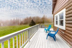 MontgomeryModern Log Chalet - Upper Level的两把蓝色椅子坐在房子的甲板上