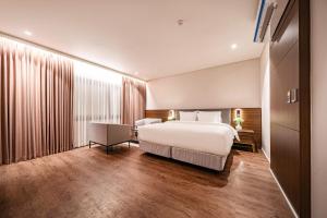 木浦市Cloud in Hotel Mokpo Peace Square的卧室配有一张白色大床和一张书桌