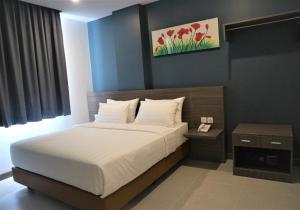 班达亚齐班达亚齐艾亚尼酒店的一间卧室配有一张大床和一个床头柜