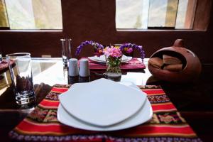 皮萨克Rumi Lodge Pisac的一张桌子,上面有白色的板子和鲜花