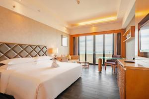 三亚三亚福朋喜来登酒店(市区海景酒店，本地美食)的酒店客房设有一张大床和一张桌子。