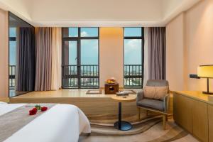 佛山佛山金美域林禧酒店的酒店客房带一张床、椅子和窗户