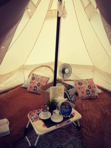 丹那拉打The Backyard Glamping Cameron Highlands的帐篷顶部带茶具的桌子