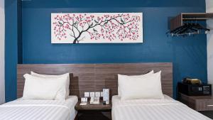 班达亚齐班达亚齐艾亚尼酒店的一间卧室设有两张床,墙上挂着一幅画