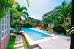 巴斯科Villa de Babat的一座棕榈树游泳池和一座建筑