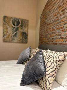 特科早特拉Hotel Del Valle的一间卧室设有砖墙和一张带枕头的床