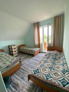 Bulan SogottuuGuest House Regina的一间卧室设有两张床和窗户。