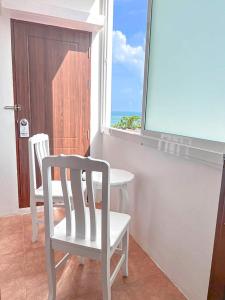 芭东海滩88 House Patong的一间设有两把椅子、一张桌子和一个窗户的房间