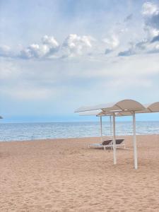 Bulan SogottuuGuest House Regina的海滩上的两把椅子和遮阳伞