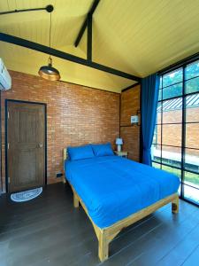 Ban Huai RinThe Maewin Coffee & Cottage Economy Double Room的一间设有蓝色床的砖墙卧室