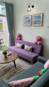 伯恩仓Sweet Homestay 3RM @ Penthouse Apartment in Brinchang的客厅配有紫色沙发和桌子