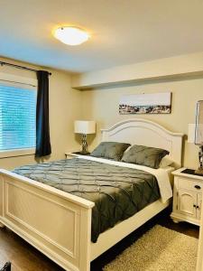 纳奈莫A Cozy Family get away suite in South Nanaimo的一间卧室设有一张大床和一个窗户。