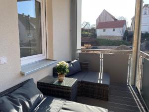 欣费尔德Wohnung für Berufstätige的阳台配有沙发、桌子和窗户。