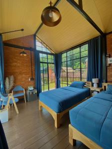 Ban Yang Huai TongThe Maewin Coffee & Cottage Economy Twin Room的配有蓝色床单的客房内的两张床