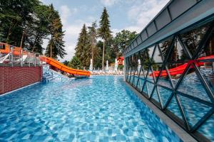 索瓦塔HOTEL CRYSTAL WELLNESS & SPA superior的一座带橙色滑梯的大型游泳池