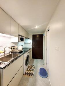 罗勇Sea Sand Sun Resort的厨房配有水槽和洗衣机