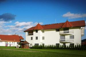 莫济列Honeycomb Chalets And Apartments Mozirje - Happy Rentals的一座白色的大建筑,有红色的屋顶