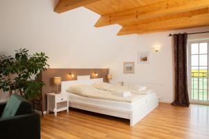 费马恩Haus im Felde Whg 6的卧室配有白色的床,铺有木地板