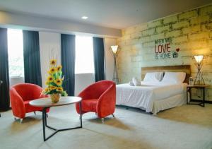 怡保Hotel Pi Ipoh的一间卧室配有一张床、两把椅子和一张桌子