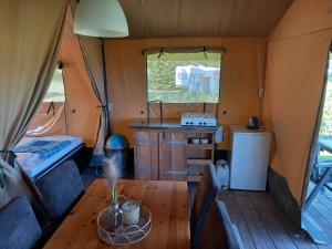 ZwiggelteComfort Safaritent Jungle - 6 personen的帐篷内带桌子的用餐室
