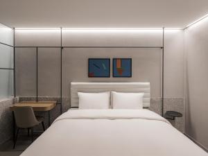 光州Ramada Plaza by Wyndham Chungjang的卧室配有一张白色的大床和一张桌子
