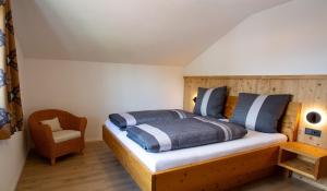 普夫龙滕Alpinchalet的一间卧室配有一张木床和一把椅子