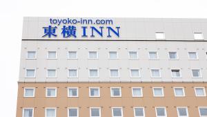 上越市Toyoko Inn Joetsu myoko eki Nishi guchi的上面有标志的建筑