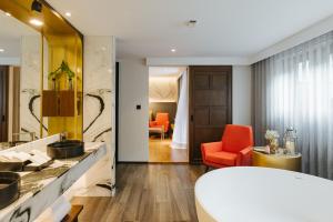 清迈Hotel Sensai Nimman Chiang Mai - Adults Only的客房内的浴室设有橙色椅子和水槽