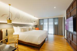 清迈Hotel Sensai Nimman Chiang Mai - Adults Only的一间酒店客房,配有一张床和一台电视