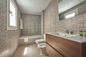 普拉加德阿罗西昌公寓酒店的一间带水槽、卫生间和镜子的浴室