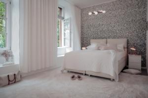 海德堡海德堡老香烟厂精品公寓式酒店的卧室配有白色的床和带图案的墙壁