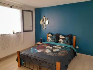 圣勒Maison de vacances Leu ti coin des ô的一间卧室配有一张蓝色墙壁的床