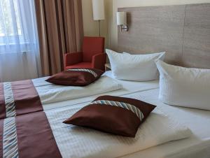 美因茨美因茨酒店的酒店的客房 - 带2张床、枕头和椅子