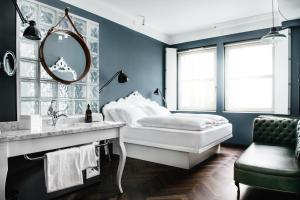 维也纳维也纳市中心费迪南德大酒店的一间蓝色卧室,配有一张床和镜子