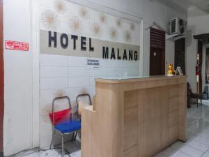 玛琅Hotel Malang near Alun Alun Malang RedPartner的墙上有一张有两把椅子的马朗标志